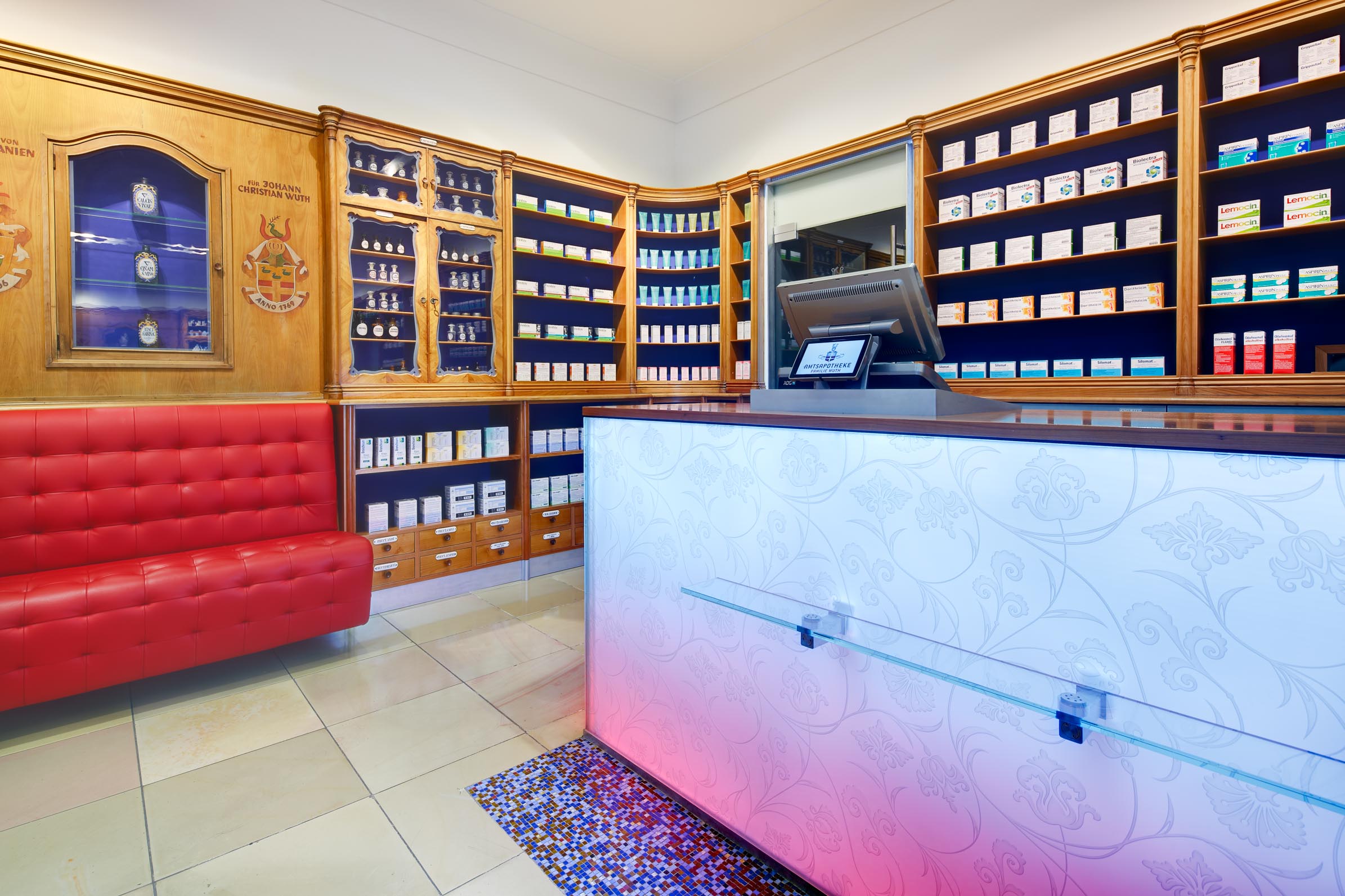 Historic medicine display with restored shelving and colour-accented back panels