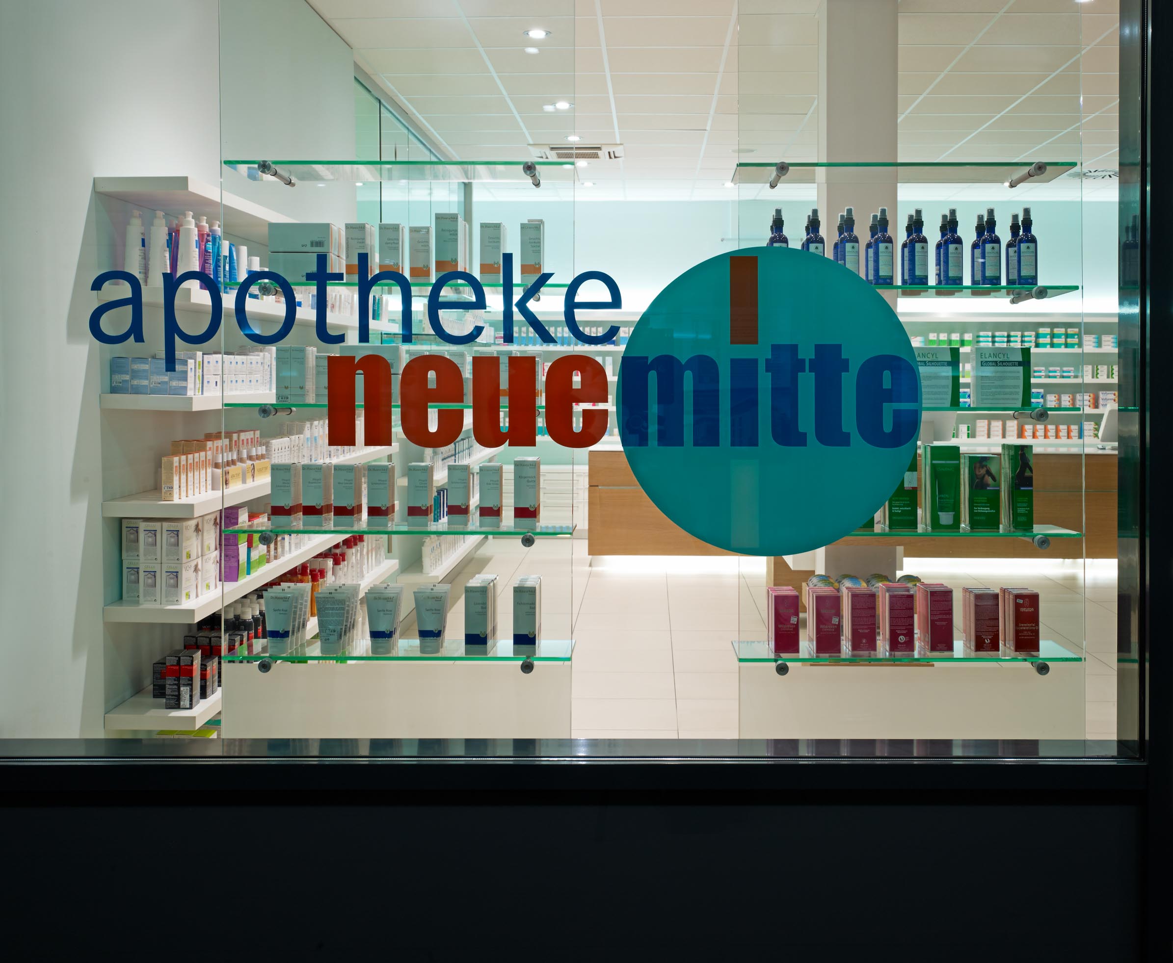 Schaufenster der Apotheke Neue Mitte in Essen mit Logo und Blick auf die helle Freiwahl